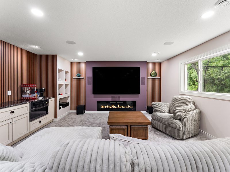 A finished lower level with a seating area and built-in cabinetry.