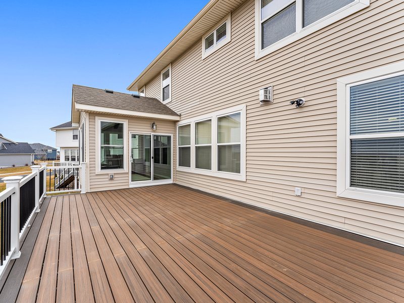 A composite deck with railing overlooking an open back yard in the Twin Cities.