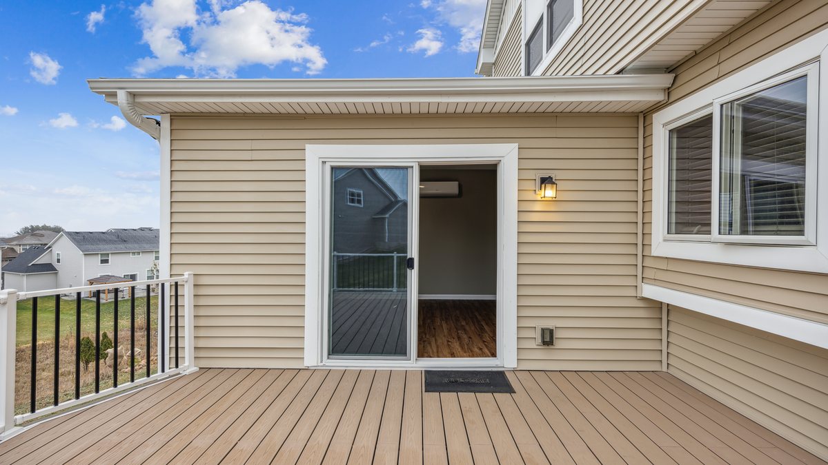 A composite deck with an aluminum guard and open stair flight, off a walkout door.