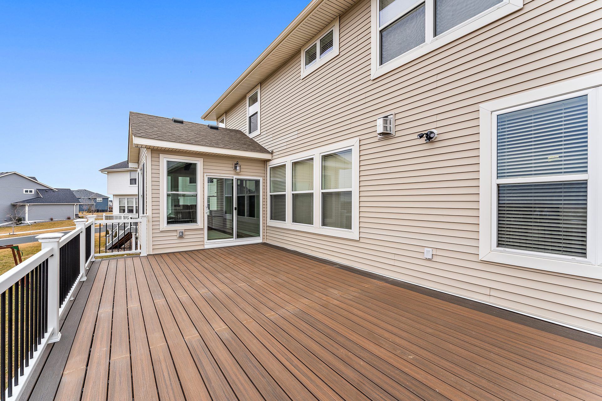Composite deck running along the rear elevation to a sunroom, with a black metal guard