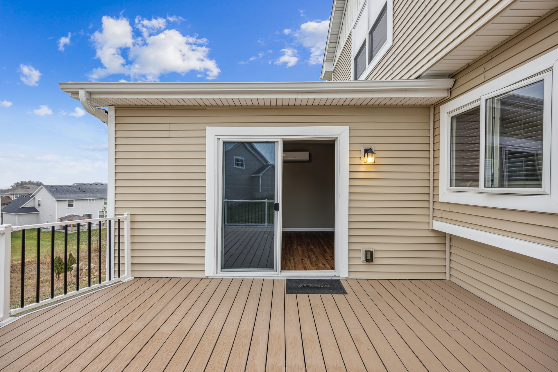 Composite deck at a sliding door with a black metal guard and a covered soffit above