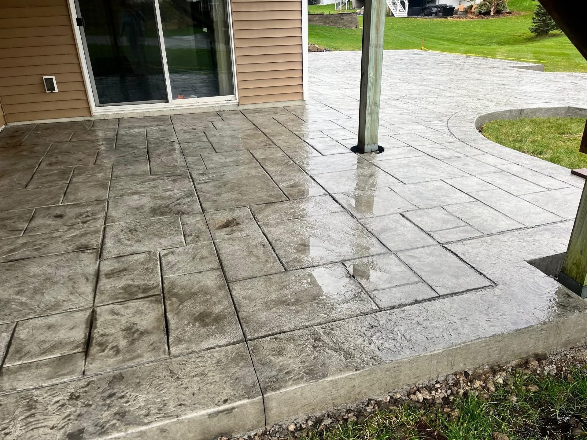 Stamped concrete patio in a running-bond pattern at a sliding door