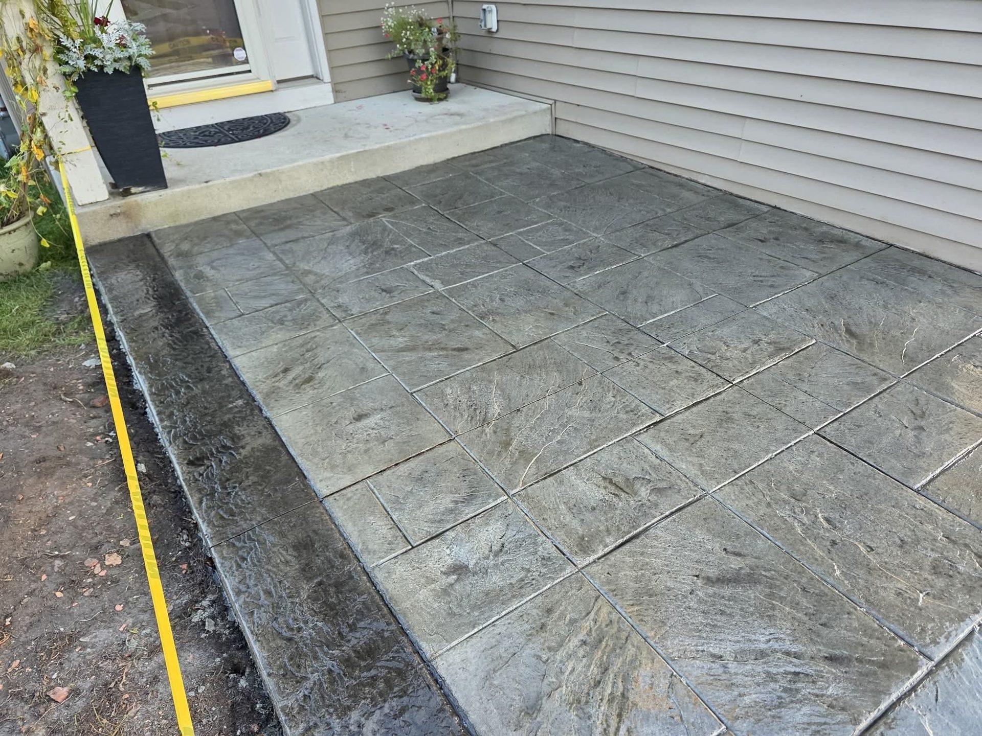 Stamped concrete patio at a back entry, with the layout line still marked on the edge