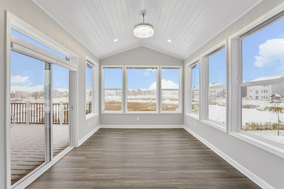 Finished four-season porch addition with wraparound windows, vaulted ceiling and pendant lighting