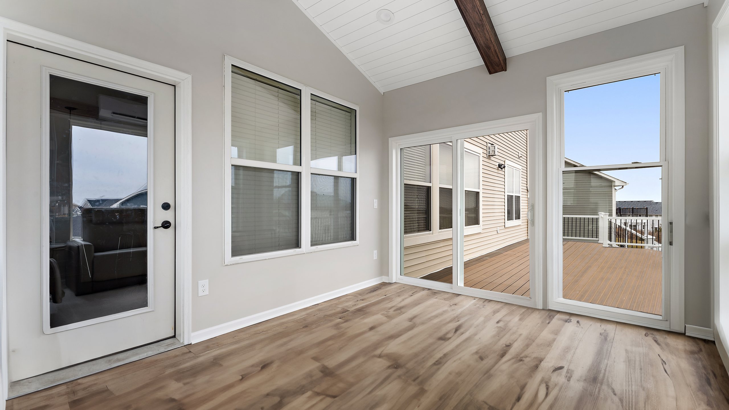 A four-season addition with a vaulted ceiling, exposed beam and full-height windows.