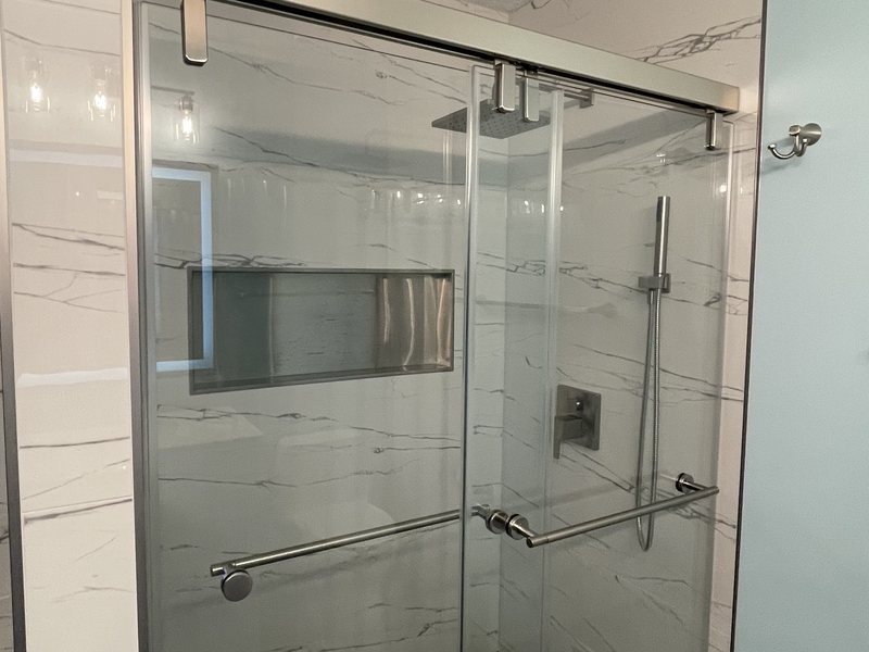 A glass shower enclosure with large-format wall tile.