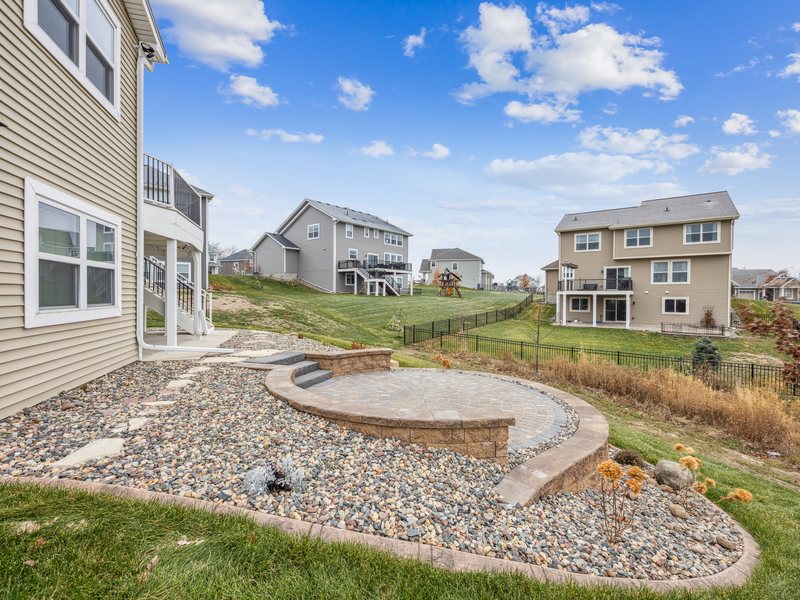 A stamped concrete patio and fire pit set into a lawn.