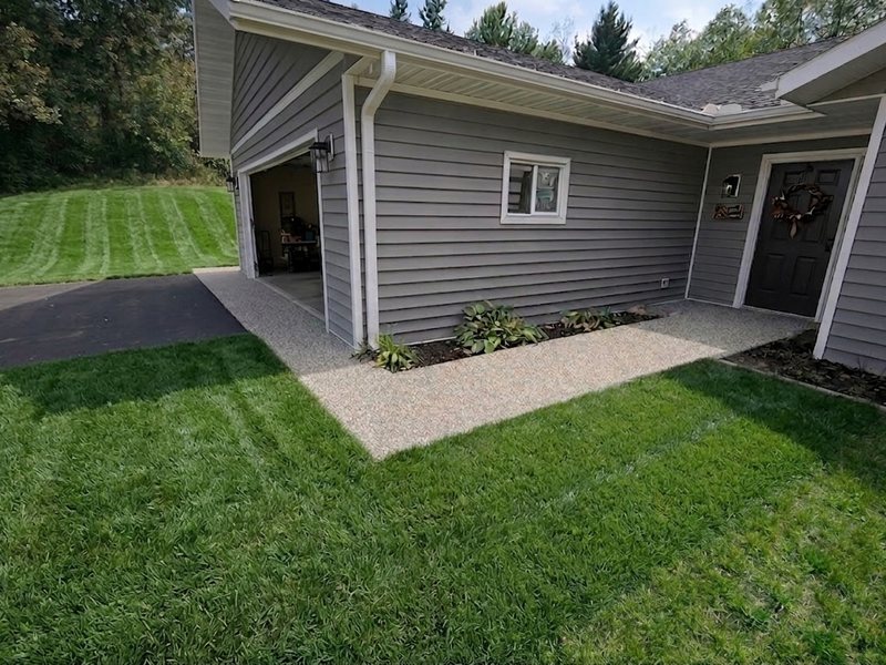 A resin-bound surface laid joint-free against a lawn edge.
