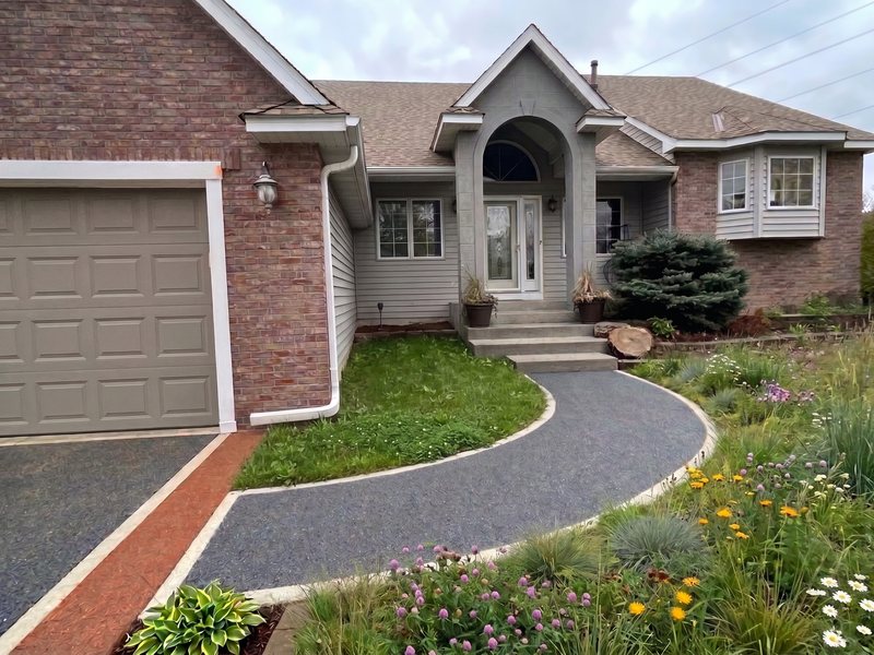 A resin-bound driveway of natural stone aggregate with a contrasting border.